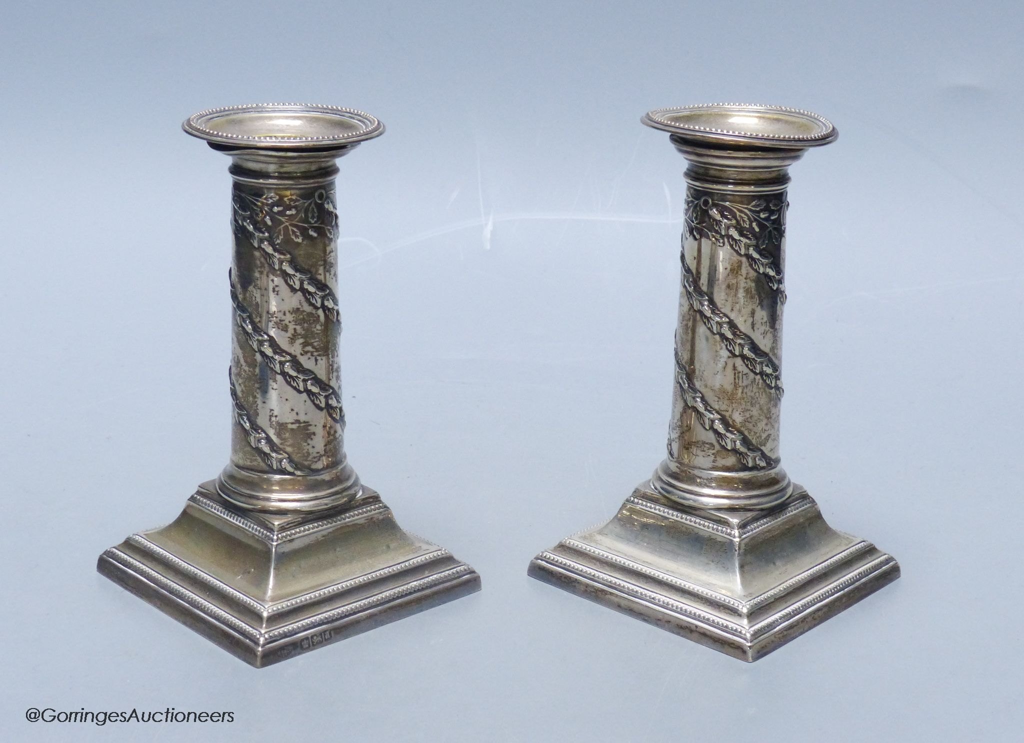 A matched pair of late Victorian silver dwarf candlesticks, Hawksworth, Eyre & Co, Sheffield, 1886 & 1893, approx. 13cm, weighted.